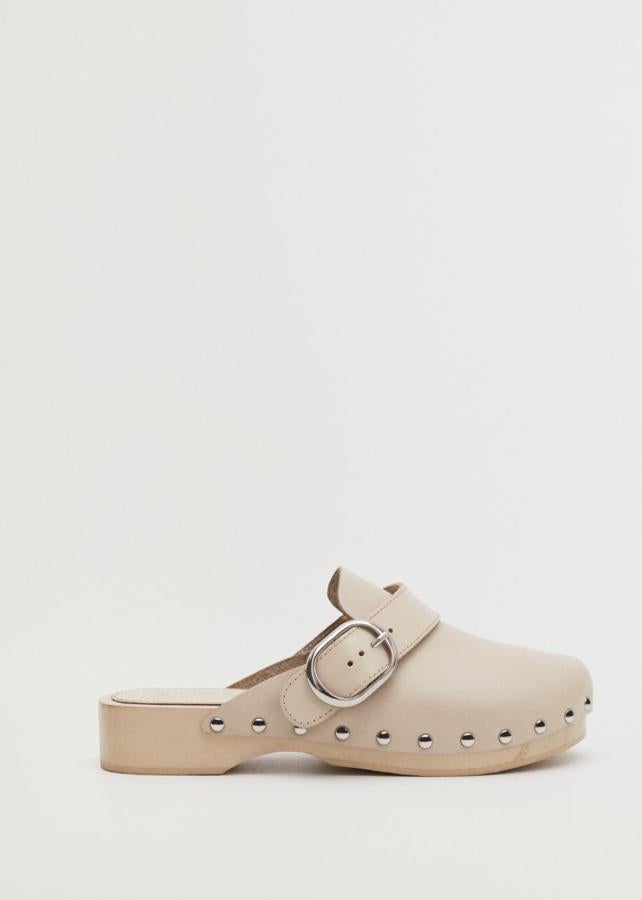 En color beige, este zueco de piel con puntera redonda, suela estilo madera y detalle de tachuelas tiene un precio de 49,99 euros.