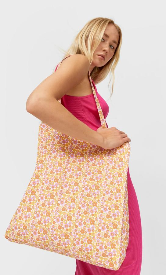 Con estampado en rosa, naranja y mandarina, este shopper estampado de Stradivarius con asas largas y de diseño vertical tiene un precio de 9,99 euros.