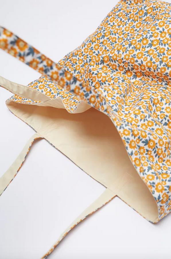Otra de las apuestas por el naranja es este shopper de Zara con asas largas y diseño vertical con estampado en naranja y verde. Es reversible, con interior en amarillo pastel, y cuesta 19,95 euros.