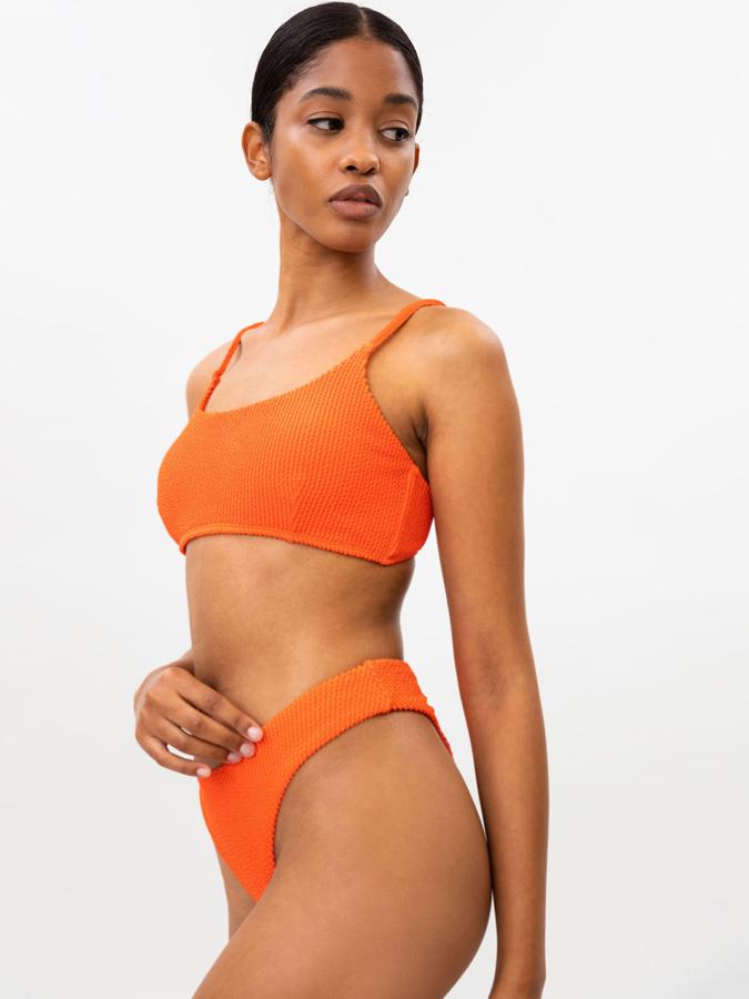 En color naranja y confeccionado en un tejido de secado rápido, este bikini de punto de canalé con rizo está formado por una braguita (7,99 euros) y un top (8,99 euros) con cierre en la espalda y tirantes regulables.