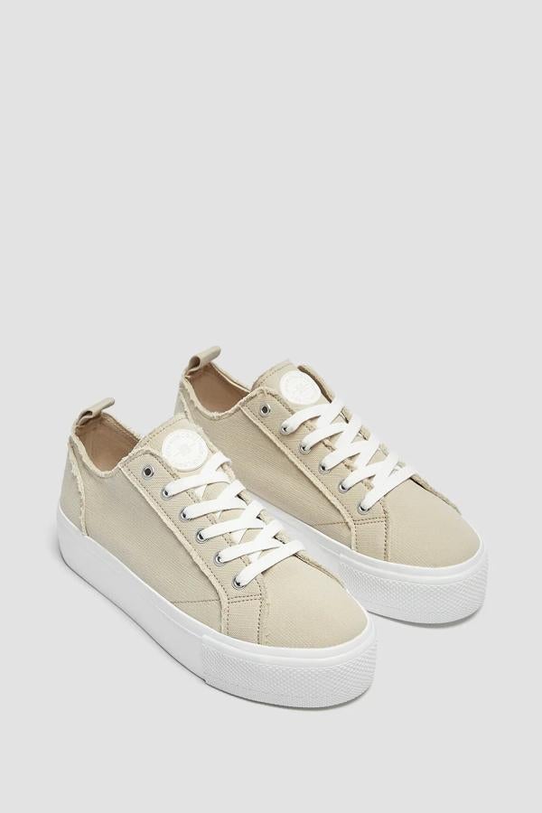 Esta zapatilla de color beige cuenta con cierre mediante cordones y tirador en la talonera. Con una suela blanca de cuatro centímetros, tiene un precio de 22,99 euros.