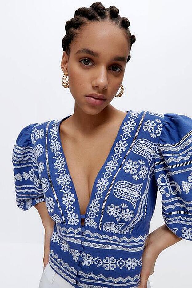 La camisa azul tiene el escote en forma de pico