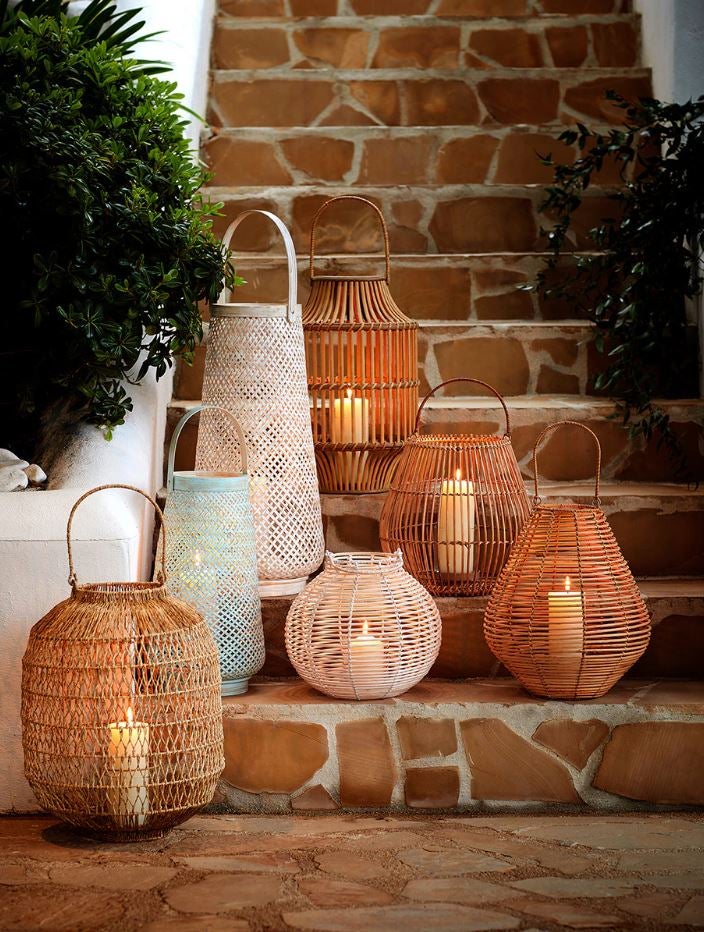La iluminación indirecta aporta calidez, elegancia y un toque de romanticismo. Estos faroles para velas en ratán están disponibles desde 24.95 euros en El Corte Inglés.
