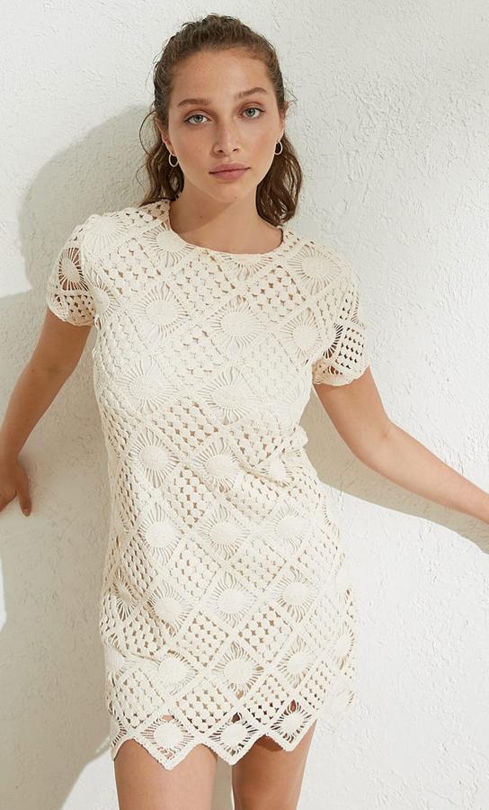 En color piedra, este vestido corto tejido a crochet de cuello redondo y manga corta tiene un precio de 29,99 euros.