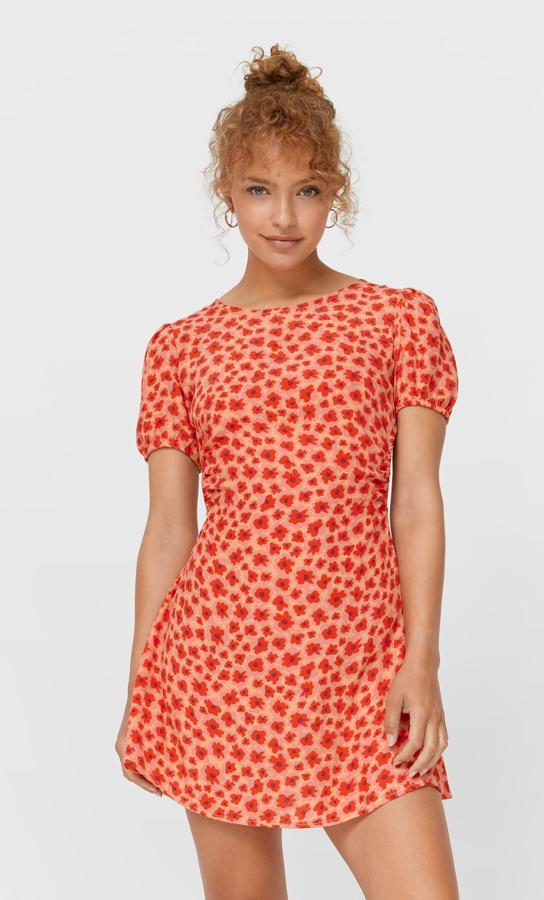 Con estampado de flores en color rojo, este vestido corto de cuello redondo y manga corta abullonada cuenta con espalda abierta con lazadas y bajo acabado en volante. Tiene un precio de 17,99 euros.