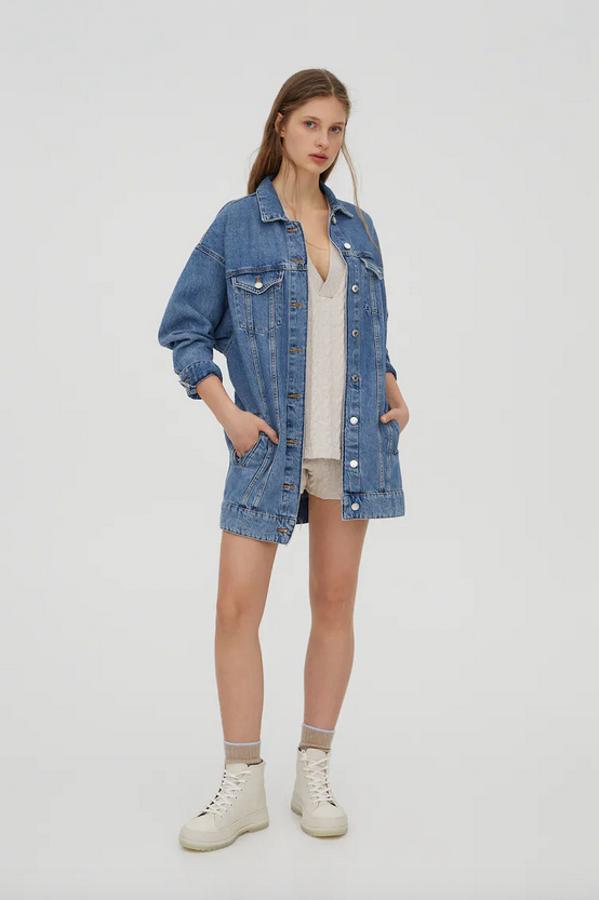 De diseño largo, con cinturón del mismo tejido, esta cazadora vaquera azul de Pull&Bear viene con bolsillos de plastrón con solapa y botón en la pechera, bolsillos laterales, costuras vistas y mangas largas. Cuesta 35,99 euros y está disponible entre las tallas XS y L.