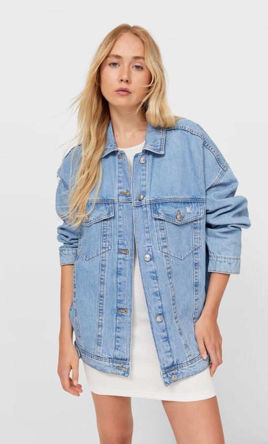 Esta cazadora vaquera en denim claro es de Stradivarius y de diseño oversize. Con cuello de solapa y manga larga, tiene bolsillos delanteros de vivo y de plastrón con solapa, detalle de rotos y cierre de botones metálicos frontal. Con un precio de 29,99 euros, está disponible entre las tallas XS y XL.