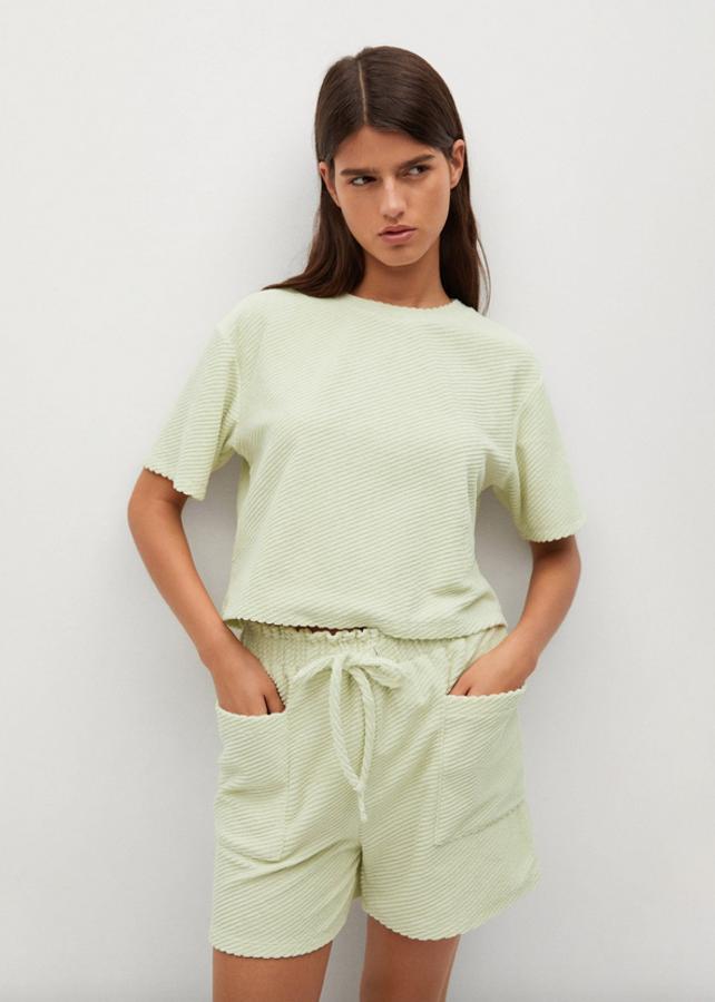 En verde pastel y en tejido toalla acanalado, esta camiseta confeccionada en algodón es de diseño cropped recto y viene con cuello redondo y mangas cortas. Disponible entre las tallas XS y XL, cuesta 19,99 euros.