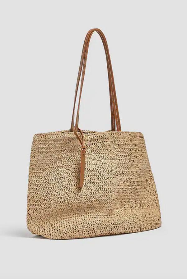 En color beige, confeccionado en papel trenzado en el corte con efecto rafia, este bolso shopper con asas de hombro a contraste y detalle de tirados con grabado, tiene cierre de imán y de 25,99 euros ha pasado a costar 19,99 euros.