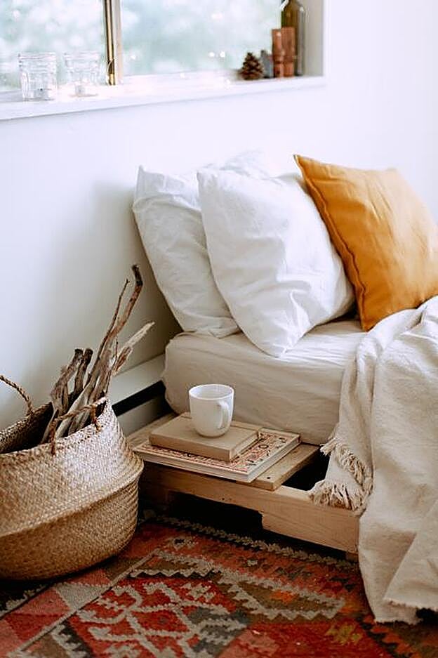 Dormitorio con ropa de cama en blanco y naranja.