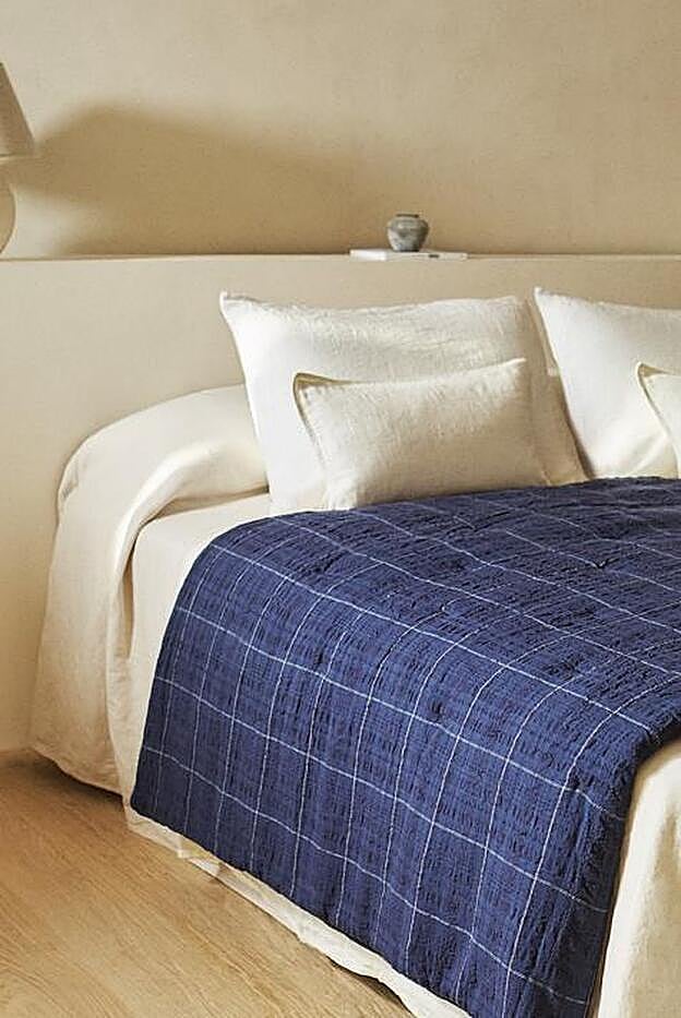 Ropa de cama en blanco con edredón en azul de Zara Home.