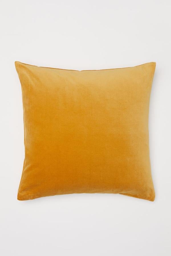 Puedes aprovechar las rebajas anticipadas de H&M Home, para hacerte con piezas de cara al otoño, como esta funda de terciopelo en color mostaza. Con el descuento se queda 5,59 euros.