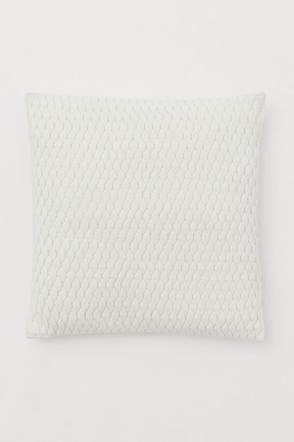 El color blanco no falla en cualquier rincón de la casa. Añade una funda de cojín en color blanco como esta de H&M Home. Tiene un descuento del 30% y esta funda se queda en 17,49 euros.