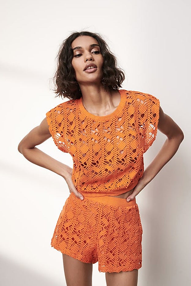 Top de ganchillo de color naranja con shorts a juego de Zara.