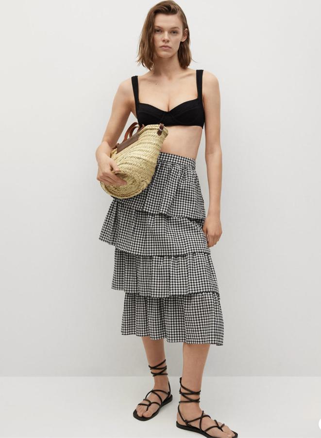 Con diseño midi y volantes, esta falda con estampado de cuadros vichy en blanco y negro cuenta con cintura alta y tiene un precio de 39,99 euros.