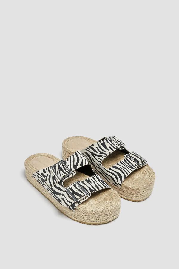 Con estampado de cebra, esta sandalia aplana con dos tiras con hebilla en la parte delantera es de Pull & Bear y tiene un precio de 29,99 euros.
