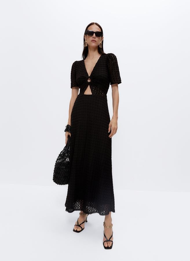 Con detalle cut out en la cintura con una anilla, este vestido evasé de color negro tiene un precio de 99 euros.