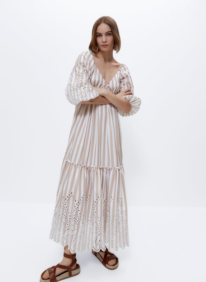 Con estampado de rayas en blanco y beige, este vestido largo con bordados con motivos florales cuenta con manga abullonada con piño elástico y tiene un precio de 159 euros.