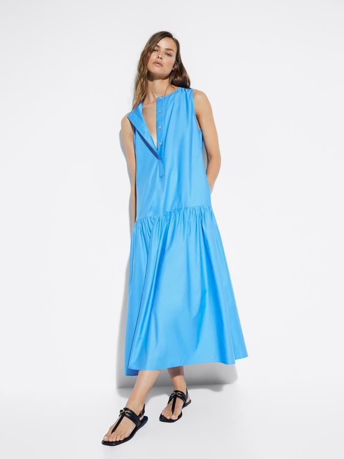 En azul celeste este vestido de corte holgado está confeccionado al 100% en algodón y viene con cuello redondo, sin mangas y con dos bolsillos laterales. Con cierre de botonadura frontal oculta por tapeta y podemos encontrarlo entre las tallas XS y L por 79,95 euros.