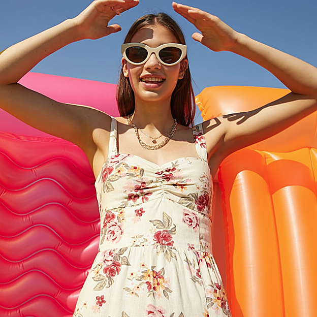 Vestido de color crema con grandes flores rojas y amarillas de Stradivarius.