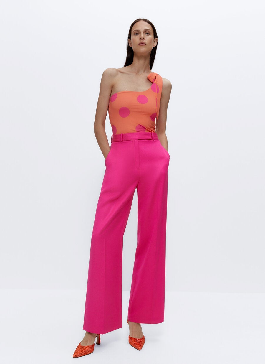 Pantalón recto de talle alto (79 €) combinado con bañador de tirante asimétrico con estampado de lunares (69 €) y sandalias de strass (99 €), todo de Uterqüe.