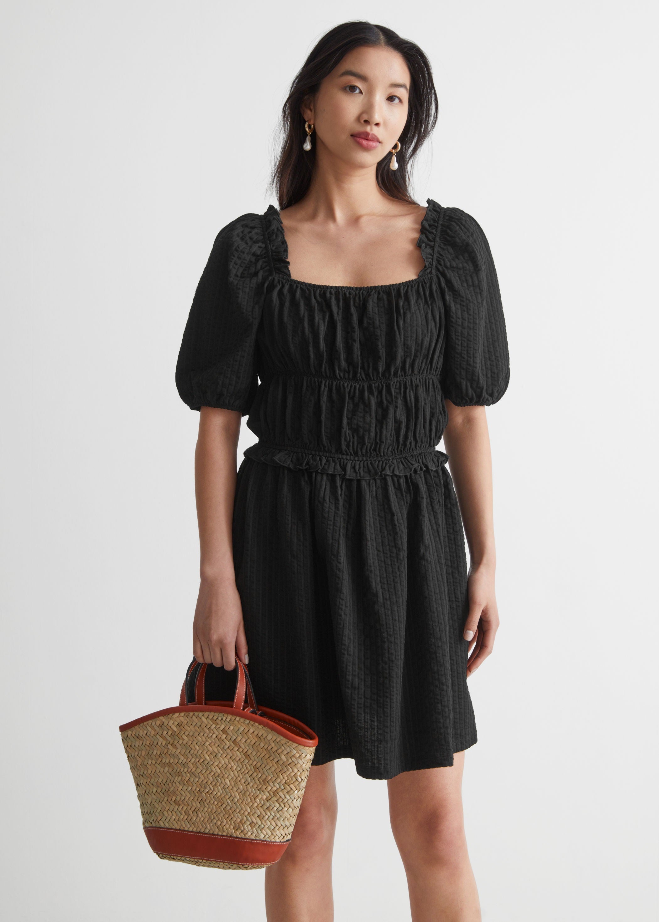 Vestido negro voluminoso con escote recto y mangas puffy de &Other Stories. (69 euros).