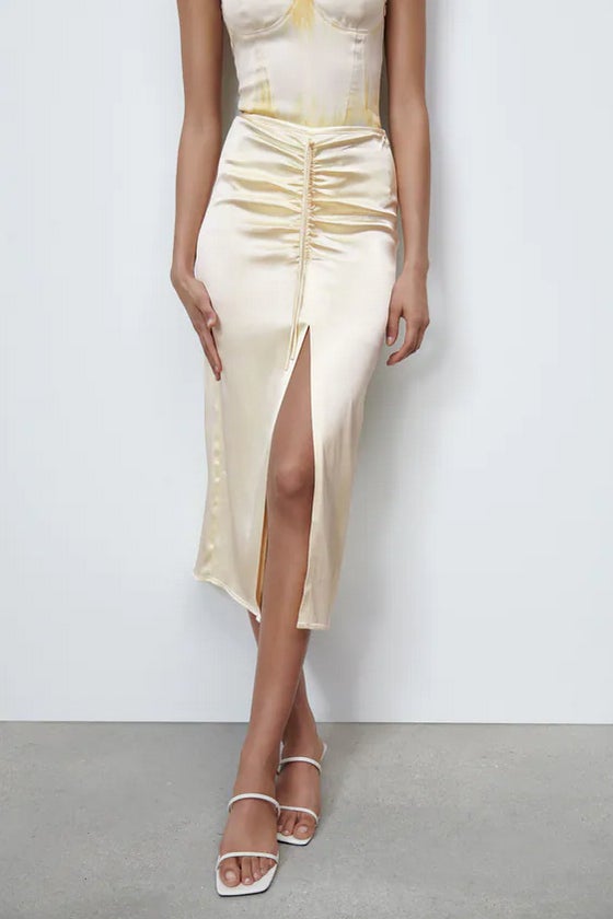 En amarillo pastel, de tiro alto y cintura elástica, esta falda midi satinada en amarillo pastel con detalle de frunce ajustable con cordones en delantero a tono. De 22,95 euros ha pasado a costar 15,99 euros. 