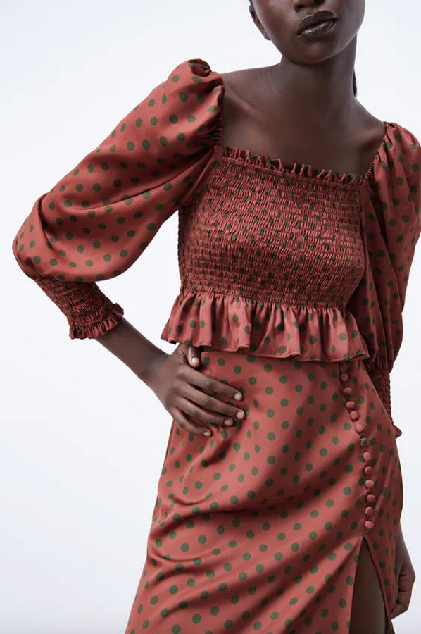 En color chocolate con lunares en verde, este top satinado viene con escote recto, mangas largas y detalle de elásticos tipo nido de abeja. Con bajo acabado con volante, de 22,95 euros ha pasado a costar 15,99 euros. 