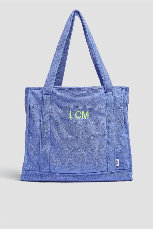 En tejido efecto toalla, este bolso maxi está disponible en malva o salmón. Con asas de hombro, cuenta con letras bordadas personalizadas y tiene un precio de 27,99 euros.