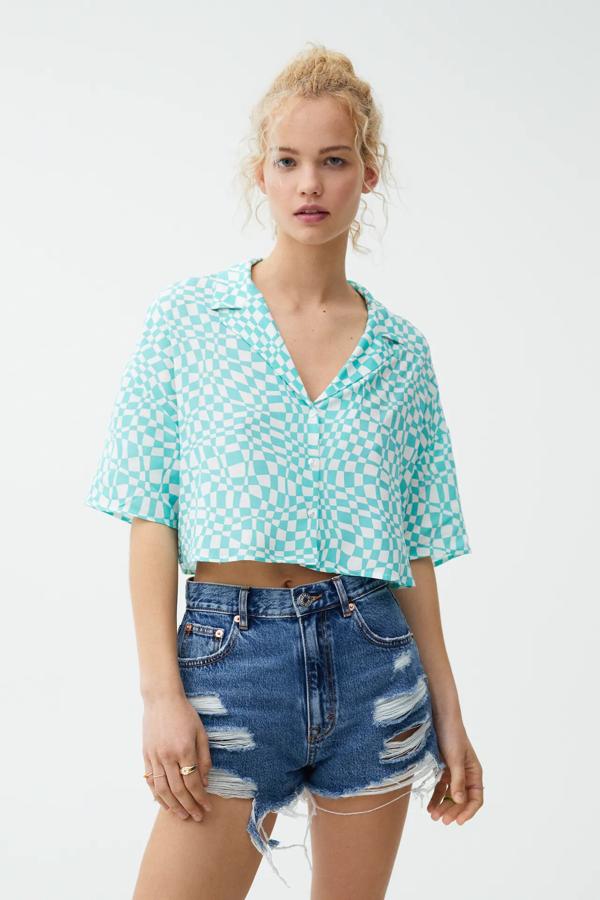 Disponible en verde o naranja, esta camisa estampada de cuadros tipo damero cuenta con manga corta y cierre de botones. Ahora tiene un precio de 12,99 euros (antes 17,99 euros).