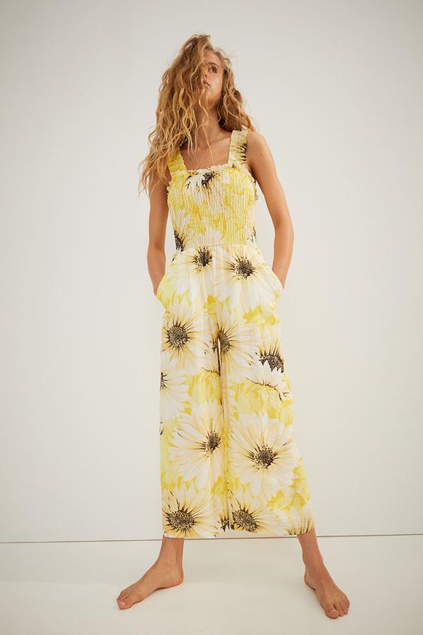 En color amarillo y estampado de girasoles, este mono tobillero con cuerpo fruncido y tirantes anchos con elástico y ribete de volante es de H&M y tiene un precio de 39,99 euros.