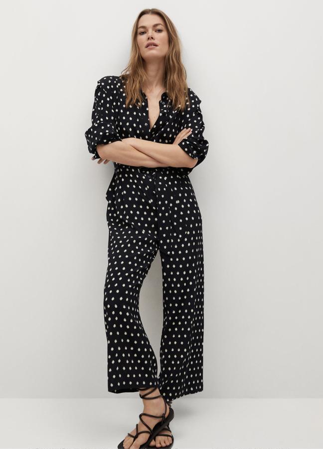 Este mono largo de color negro con topos blancos cuenta con cinturón ajustable y cierre de botones en la parte delantera. Es de Mango y tiene un precio rebajado de 19,99 euros.