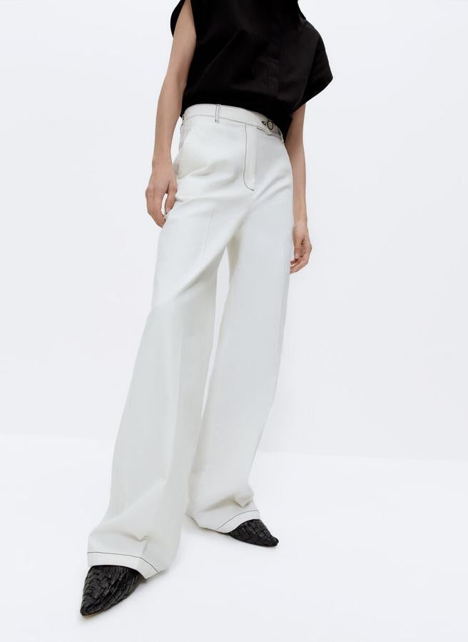 En color blanco confeccionado en tejido denim, este pantalón con pespuntes a contraste y perneras amplias viene con bolsillos laterales y cierre de botón fantasía y cremallera. De 79 euros ha pasado a costar 49,95 euros y está disponible en las tallas M y L. 
