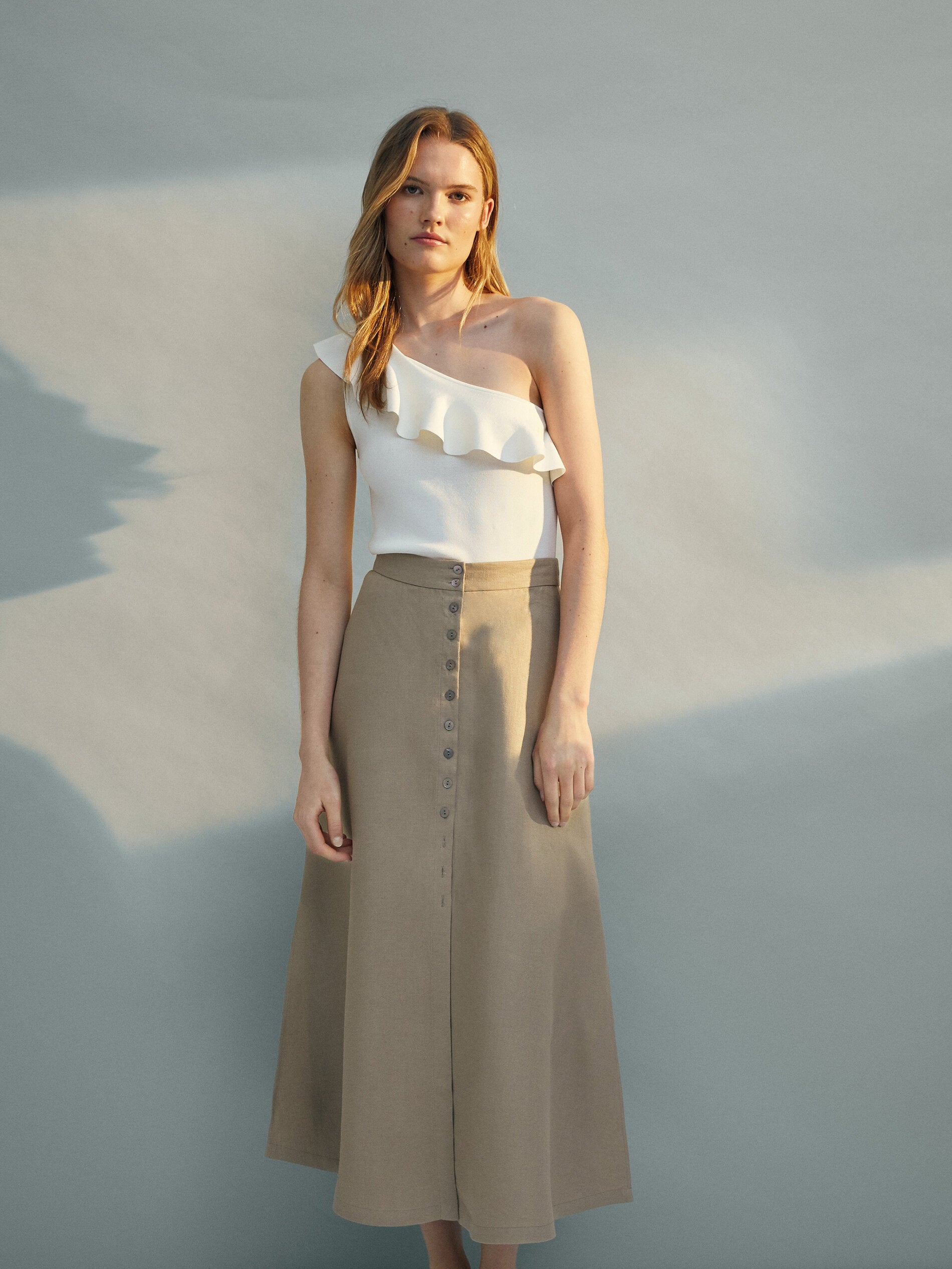 El lino es el tejido más fresco y favorecedor para el verano, y este año nos hemos enamorado de esta falda midi abotonada de Massimo Dutti (rebajada a 39.99 euros) que no te quitarás.