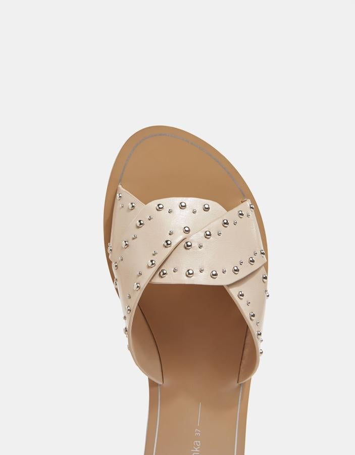 En color beige tanto la suela como el empeine cruzado y detalle de tachas en diferentes tamaños, estas sandalias costaban 19,99 euros y ahora las encontramos por 12,99 euros entre los números 35 y 41. 