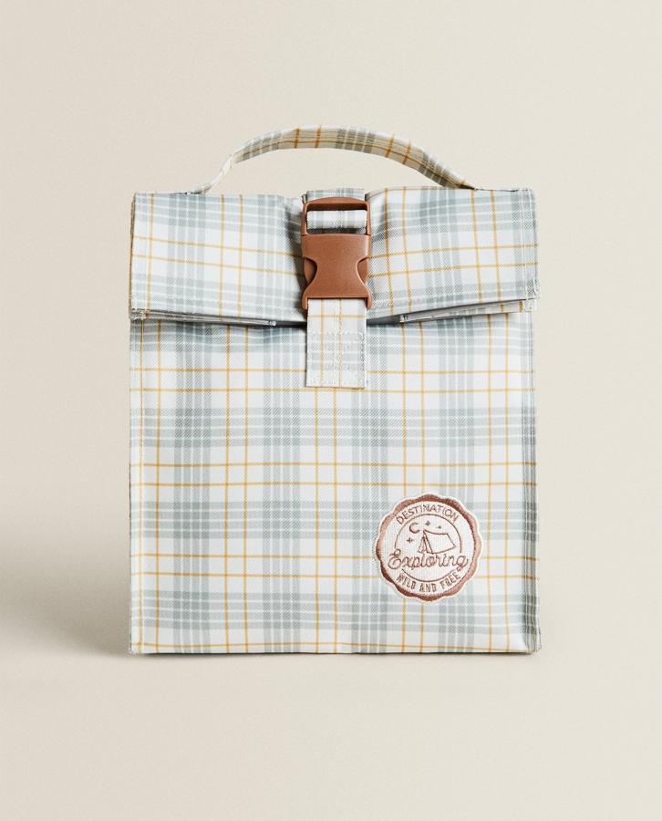 Con estampado de cuadros y detalle de parche. Esta nevera portátil se cierra con hebilla y tiene aislamiento térmico y asas para transportar. Tiene un precio de 15,99 euros.