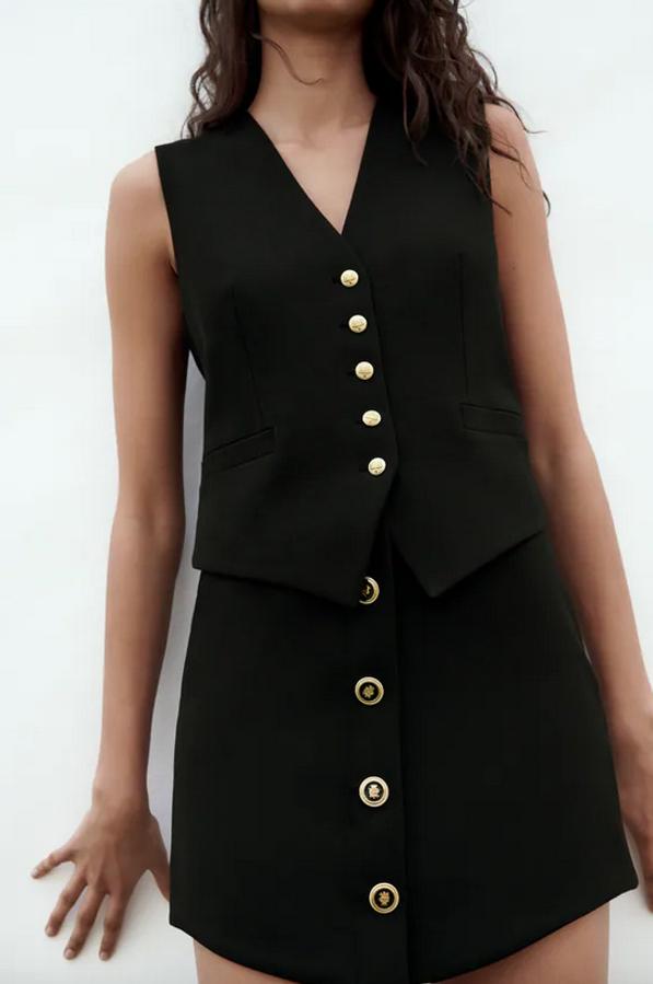 De tiro alto y cintura asimétrica, esta minifalda negra de Zara con detalle de botones en relieve en delantero combinados a contraste tiene cierre de cremallera oculta en costura y de 29,95 euros ha pasado a costar 12,99 euros y está disponible entre las tallas XS y L. 