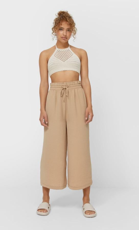 Con perneras anchas, tiro alto y cintura elástica, este pantalón culotte de Stradivarius con cordón a tono y disponible en verde, beige y negro tiene un precio de 15,99 euros y está disponible entre las tallas XS y XL.