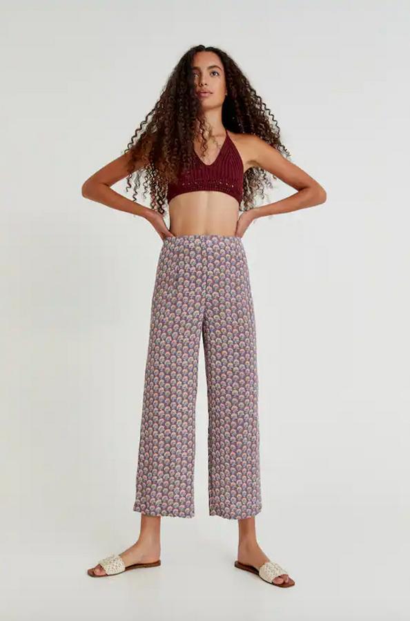 Con fondo en negro o en lila y estampado de flores beige o rosas, estos pantalones fluidos de Pull&Bear con cierre de cremallera lateral confeccionados en viscosa cuestan 19,99 euros y podemos encontrarlos entre las tallas XS y XL. 