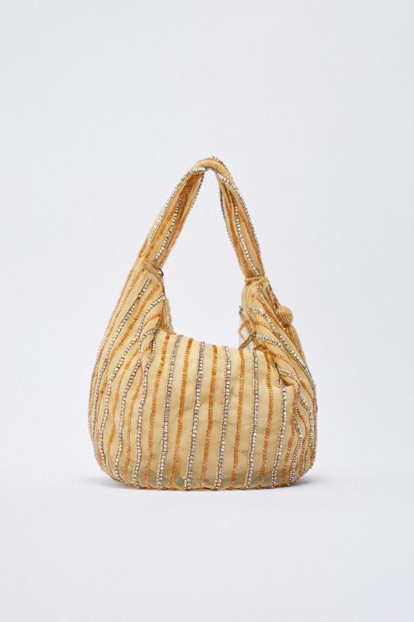 Disponible en oro o en rosado, este bolso de hombro con abalorios y cierre mediante cremallera tiene un precio de 39,95 euros.