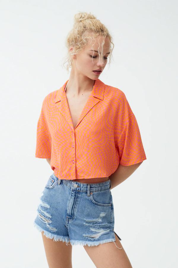 Disponible en naranja o verde, esta camisa de cuadros damero de manga corta tiene un precio rebajado de 12,99 euros (antes 17,99 euros).