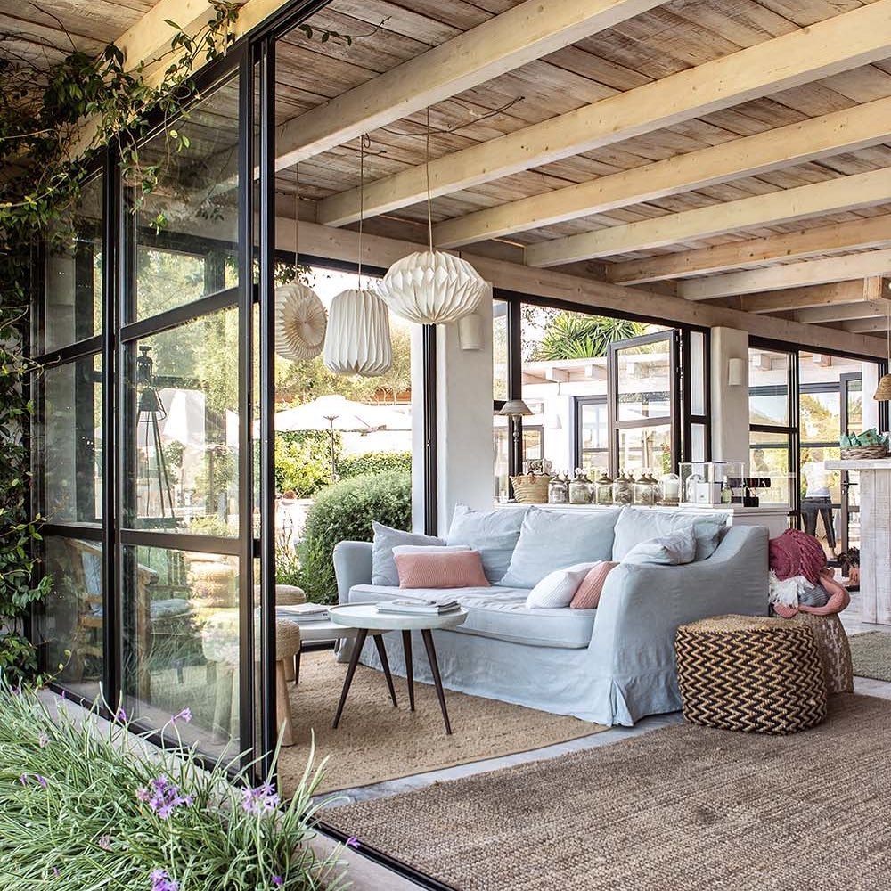 Zona común del hotel con sillones grises y alfombras de yute.