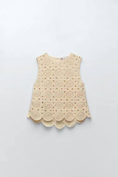 Top de crochet, con cuello redondo y manga sisa, en color arena.