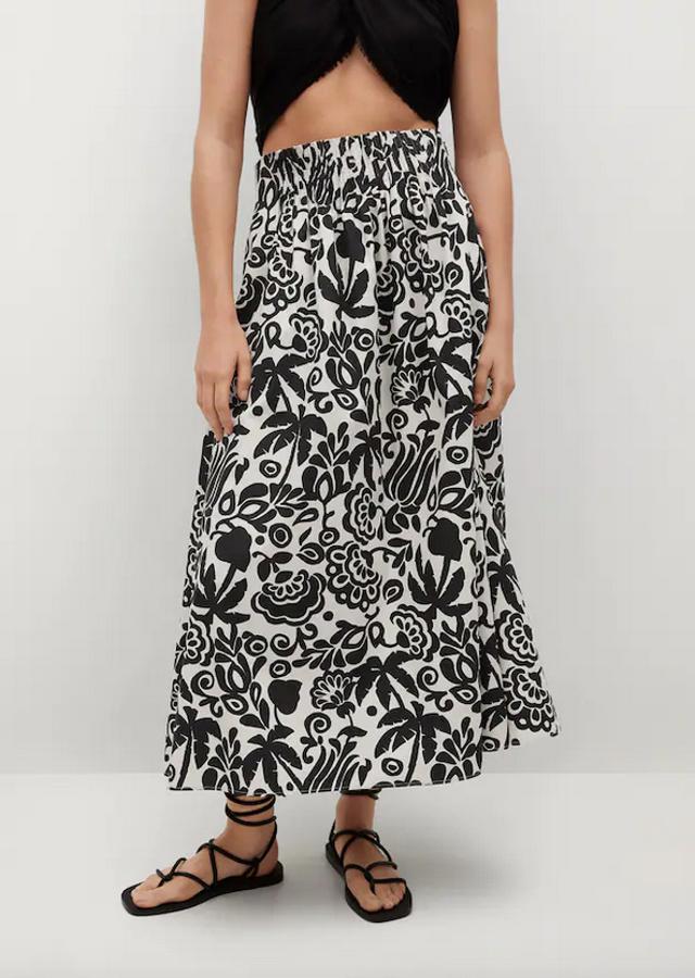 Fondo blanco con un bonito estampado en negro para esta falda midi de diseño acampanado confeccionada en algodón, de cintura alta y detalles plisados que tiene el cierre oculto de cremallera en un lateral. Está de rebajas en Mango y de 39,99 euros ha pasado a costar 27,99 euros. Únicamente queda en las tallas XS y S.