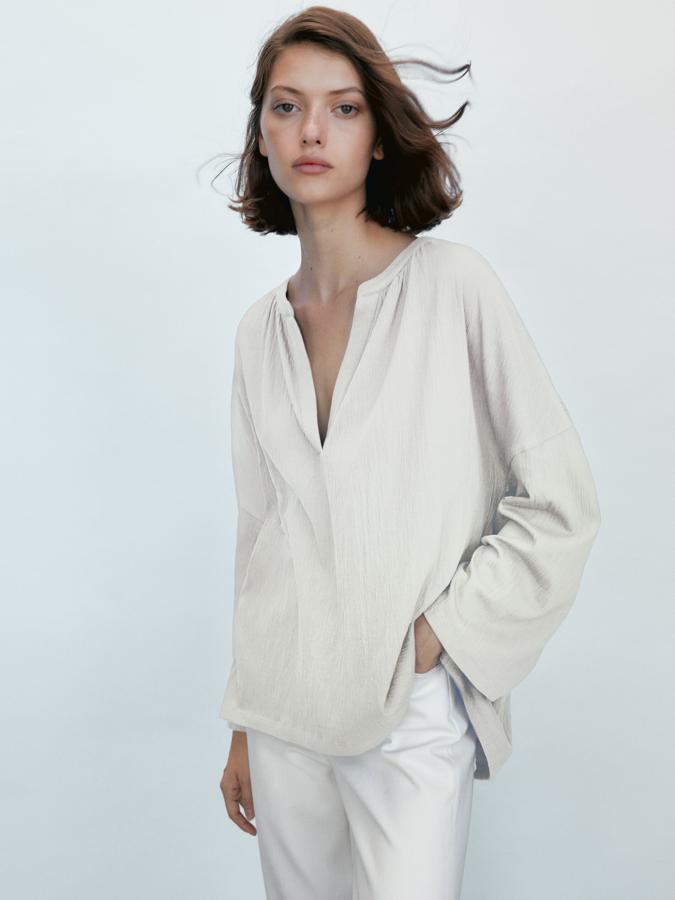 Esta blusa de manga larga y escote de pico está confeccionada en bambula de algodón y está disponible en crudo o en rosa. Tiene un precio de 29,95 euros.