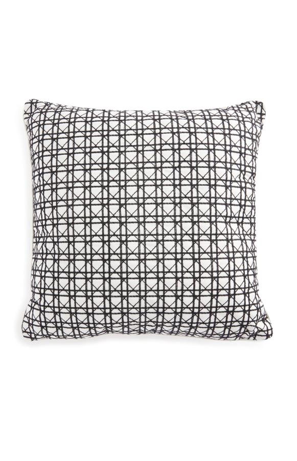 Este cojín estampado blanco y negro con tejido de caña es de Primark y tiene un precio de 8 euros.