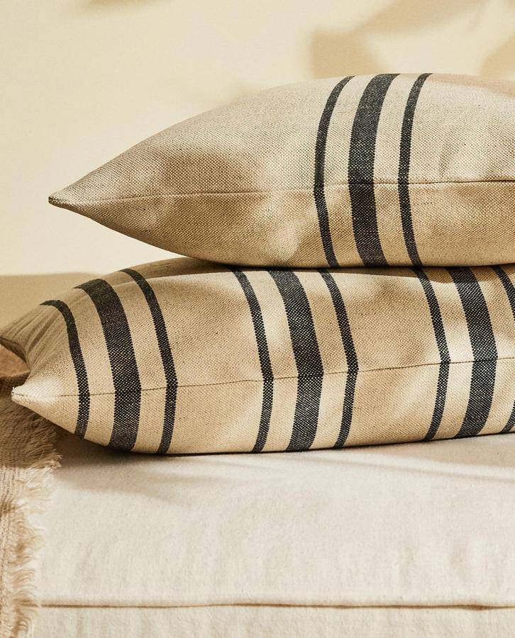 Disponible en dos medidas, 50x50 centímetros y 50x75 centímetros, esta funda de cojín de yute y lino con detalle de rayas es de Zara Home y tiene un precio de 19,99 euros o 25,99 euros dependiendo del tamaño. 