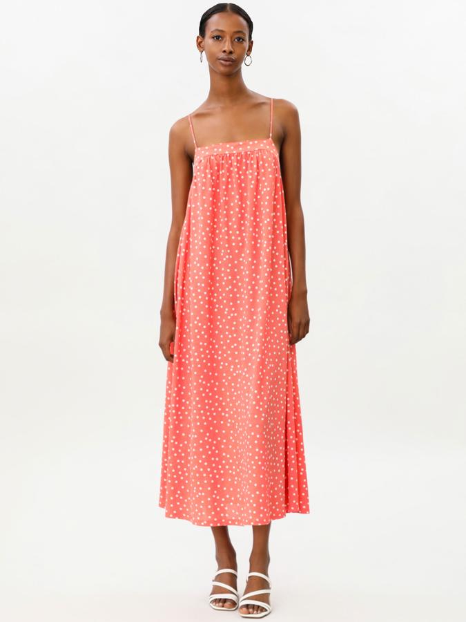 Este vestido midi de color naranja con topos blancos está disponible en otros estampados. Con tirantes finos y lazada en la parte trasera, tiene un precio de 12,99 euros.