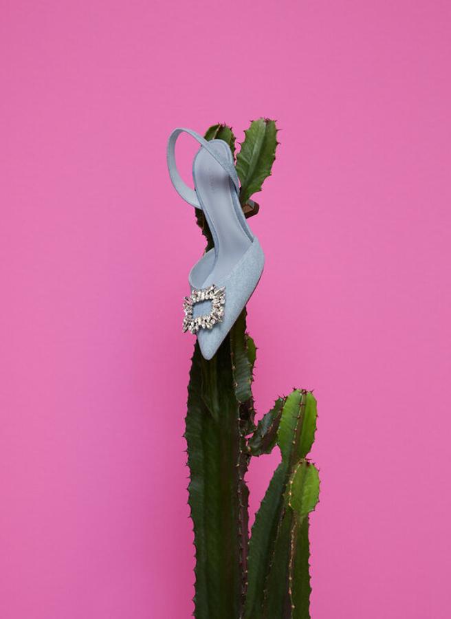 En corte de tejido denim, estos zapatos acabados en punta con tira trasera y detalle de joya en la punta vienen con tacón de 9 centímetros forrado en tejido. Tienen un precio de 99 euros y podemos encontrarlos entre los números 36 y 40. 