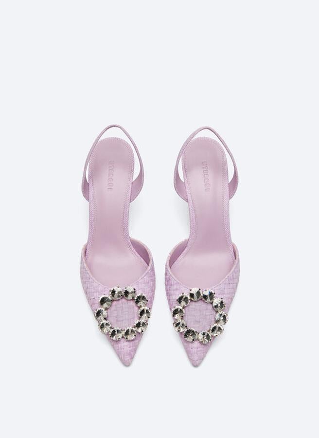 De venta exclusiva en la web de la firma, estos zapatos tipo sandalia destalonada en color lila y de corte trenzado vienen con detalle de joya circular en la pala y tacón de 8,5 centímetros. Disponibles entre los números 36 y 39, cuestan 99 euros. 